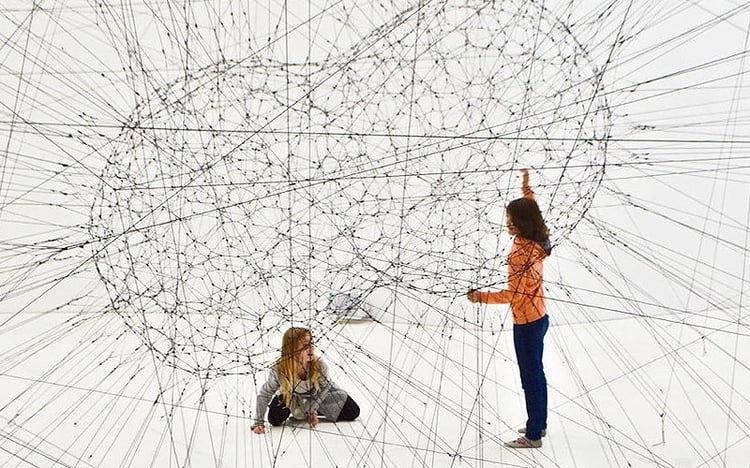 Two kids play in a web of threads 